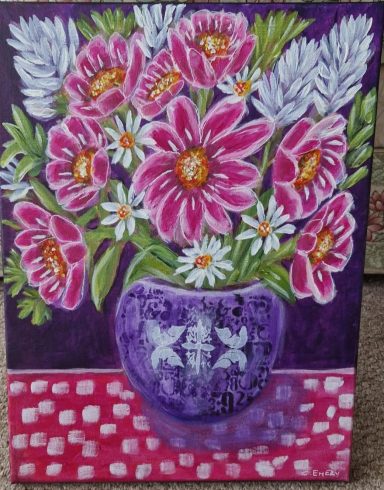 Vibrant bouquet of pink and white flowers in a purple vase on a patterned tablecloth.