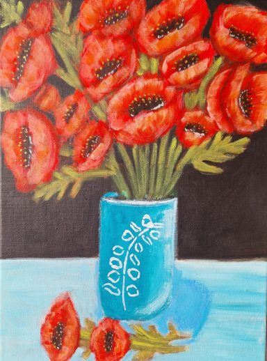 A vibrant bouquet of red poppies in a blue vase on a table.