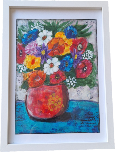 Vibrant bouquet of mixed flowers in a red vase on a blue table.