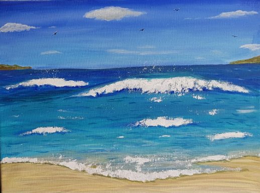 Waves crashing on a sandy shore under a clear blue sky with light clouds.