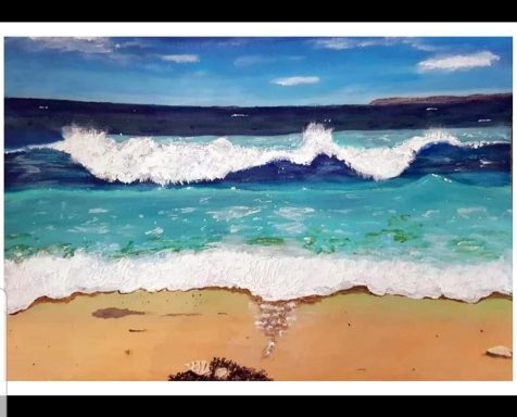Waves gently lapping at a sandy beach under a clear blue sky.